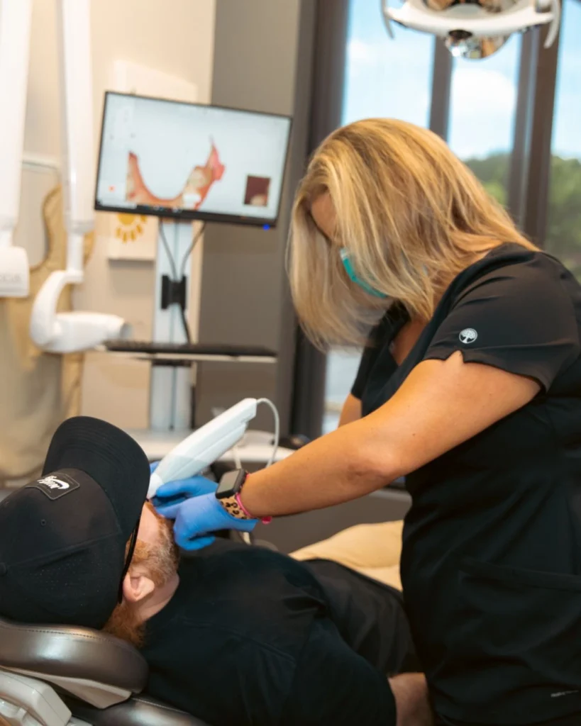 Dental assistant scanning surgical patient